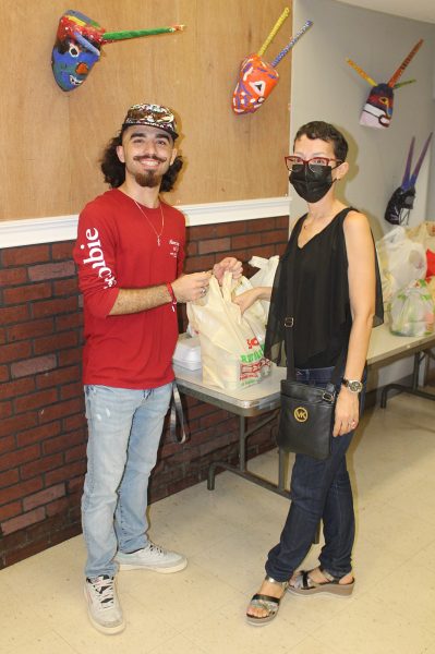La decana Grace Carro Nieves entrega alimentos no perecederos a estudiante de la Facultad de Educación.