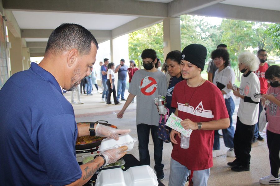 Chef Miguel Sanjurjo sirve de la paella al estudiantado.