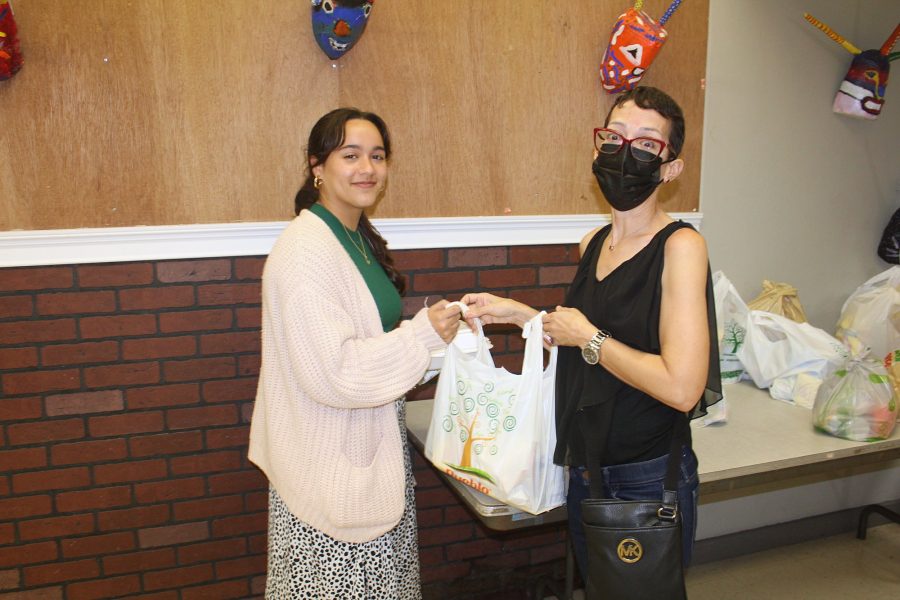 La decana Grace Carro Nieves entrega alimentos no perecederos a estudiante de la Facultad de Educación.